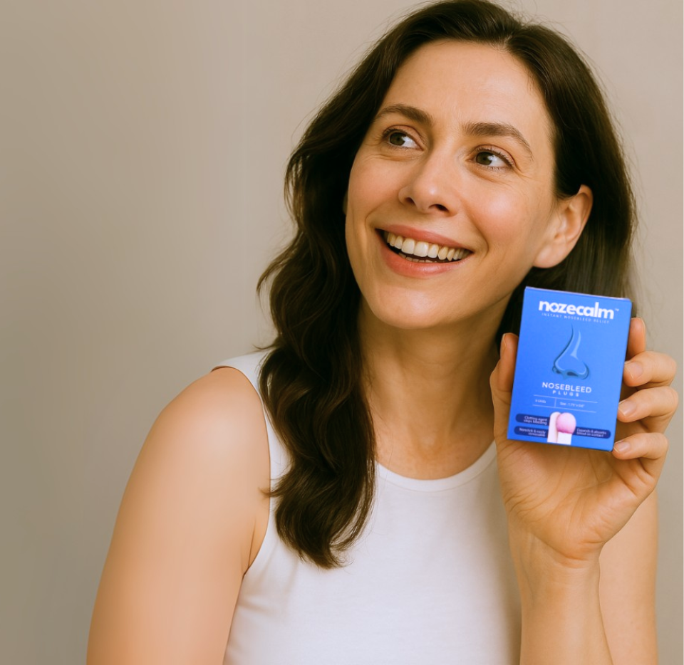 A happy customer smiling while holding her box of NozeCalm nosebleed relief plugs.