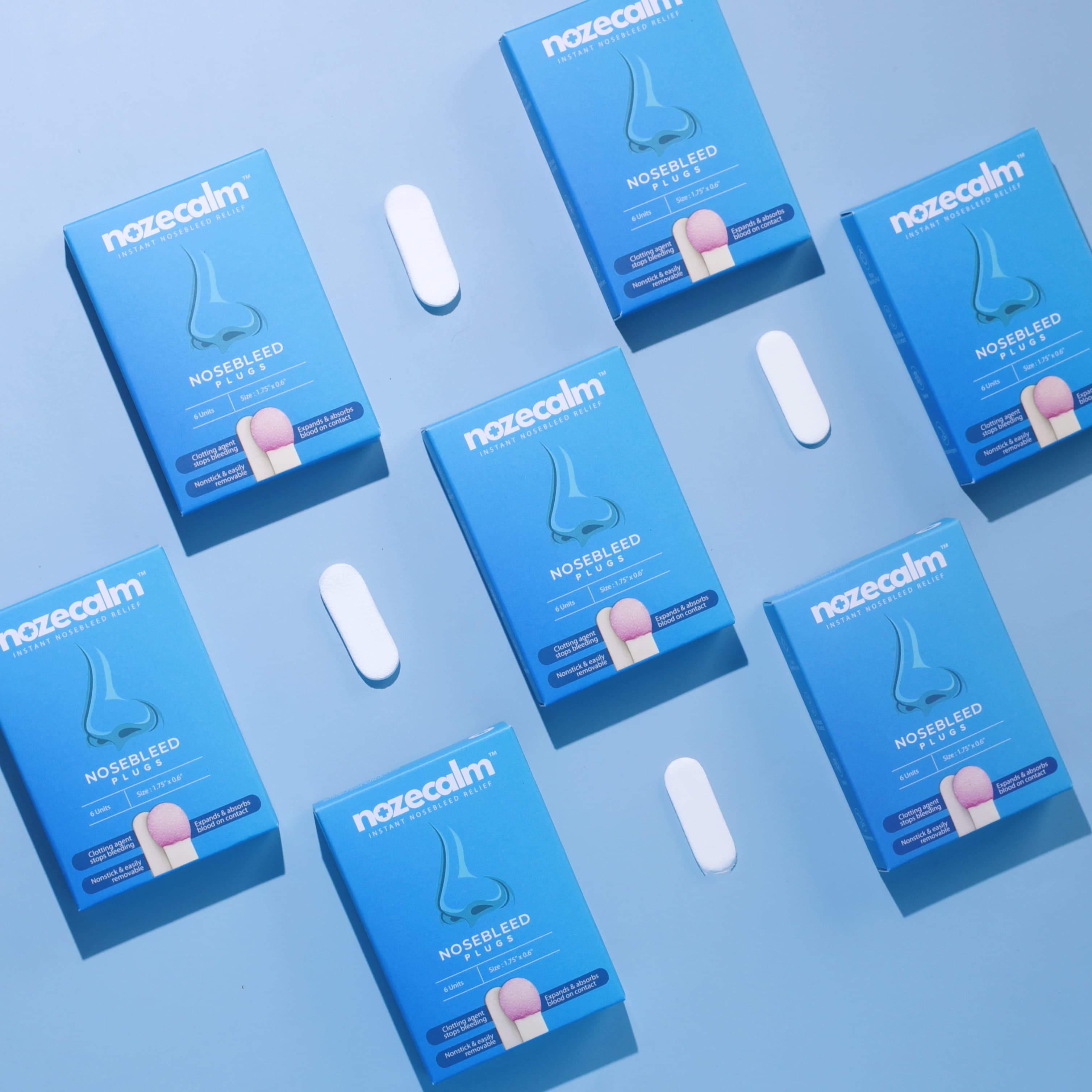 An arrangement of NozeCalm advanced nosebleed stopper boxes and individually wrapped plugs.